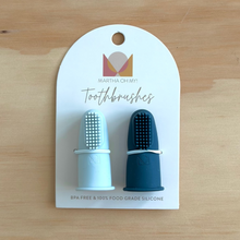 Load image into Gallery viewer, Two blue toothbrushes on a Martha Oh My! branded card against a wooden background
